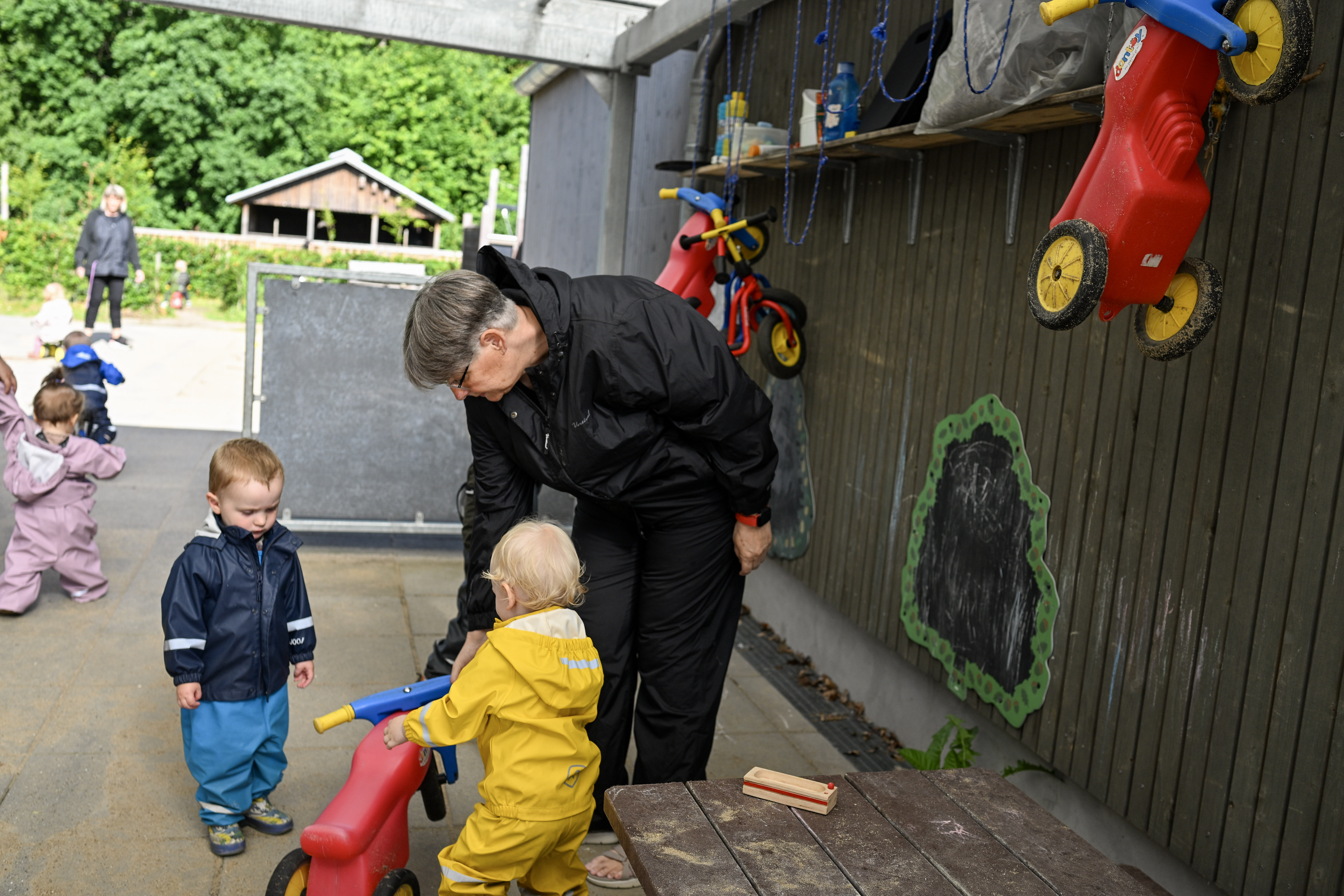 Voksen giver barn en gåcykel