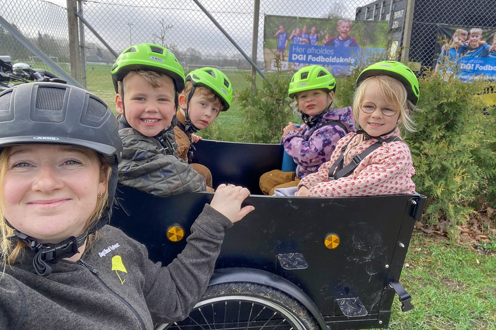 Voksen ved børn og en ladcykel