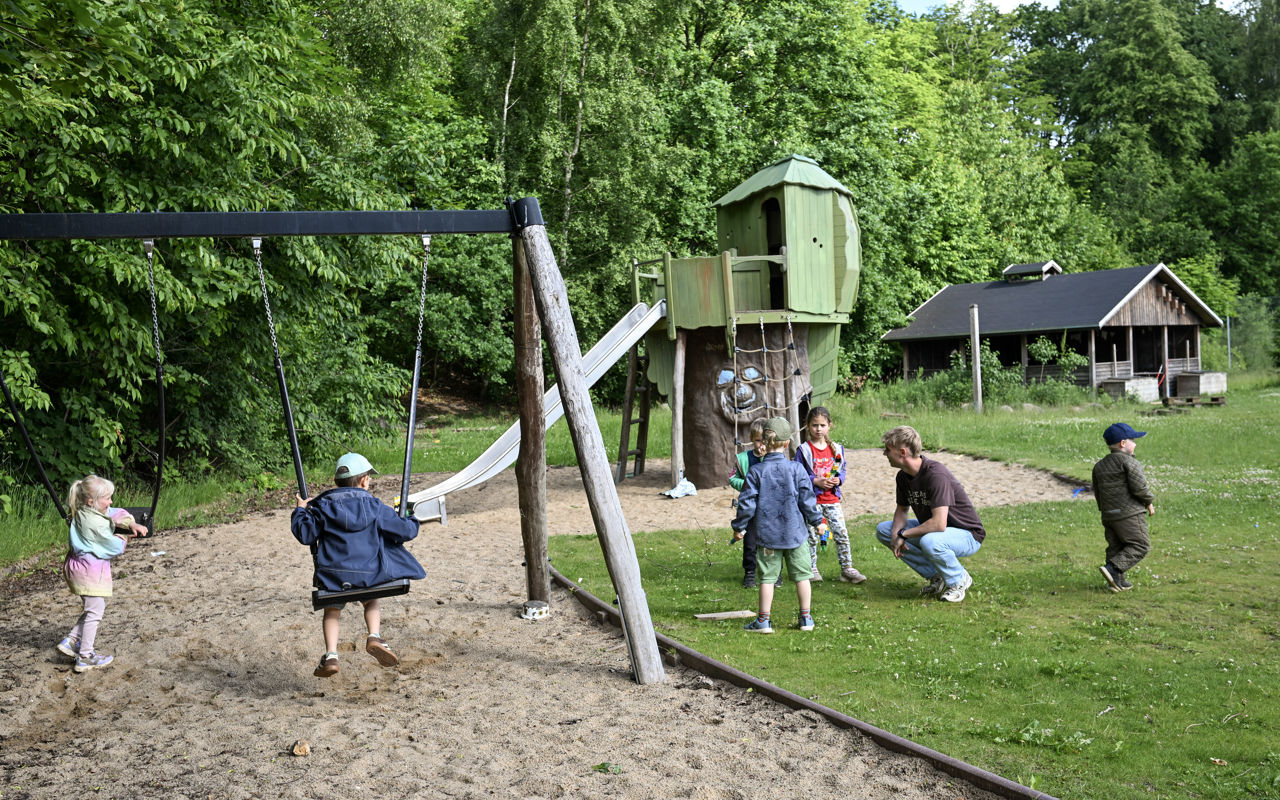 Børn og voksen på legeplads
